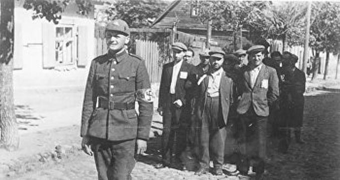 Латвийский полицейский с еврейскими заключенными, 1941 год